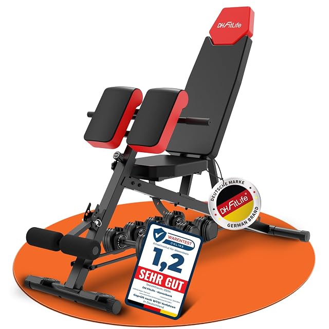 Banc 6-en-1 DH FitLife rouge et noir sur un tapis orange, haltères en dessous et carton Warentest Online 1,2
